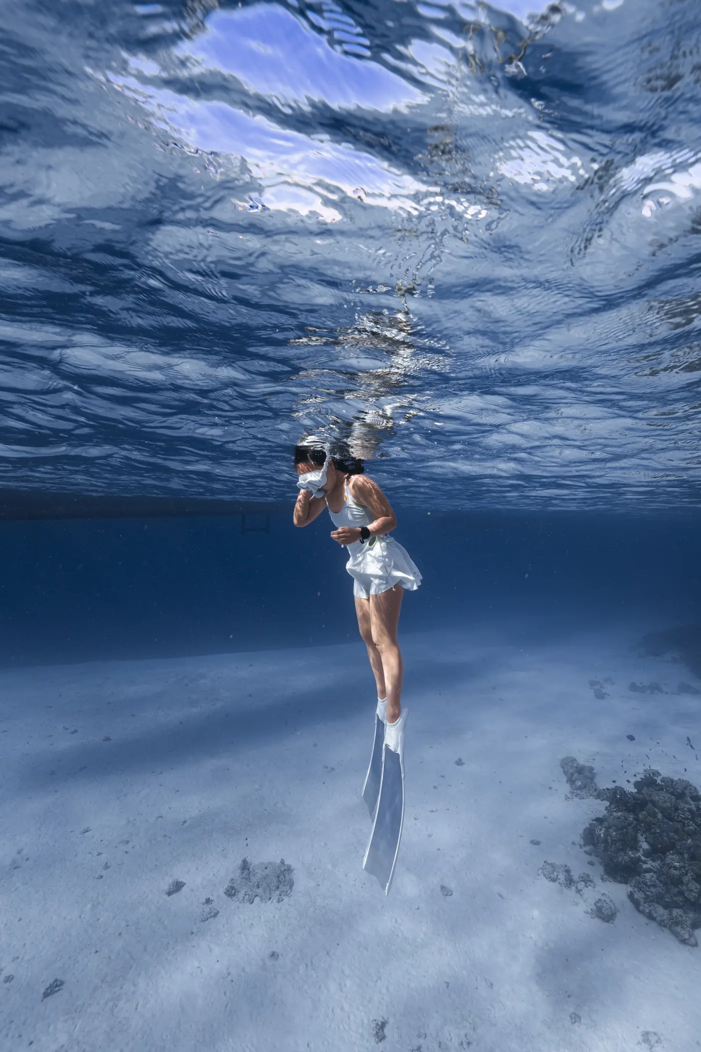 Freediver dengan kostum putih di perairan jernih, hasil sesi underwater photoshoot Walena Freedive